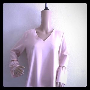 A blouse by Calvin Klein. The color is blush.